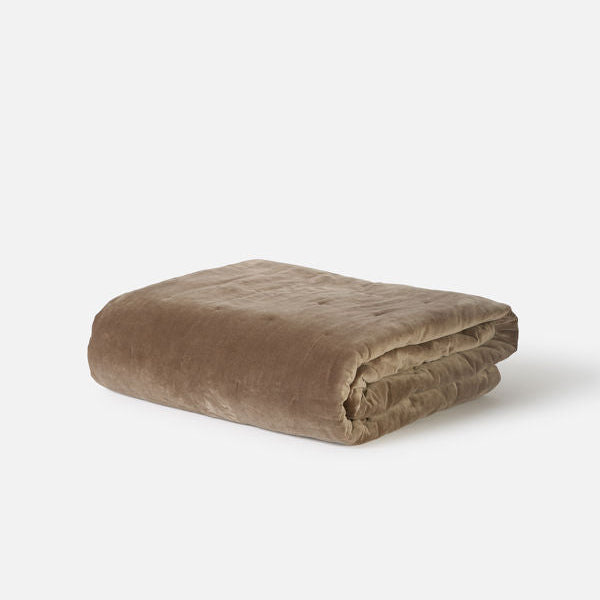 Folded brown blanket on a white background